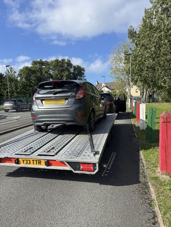Grey Ford Fiesta strapped onto the TTR transporter trailer on a sunny day