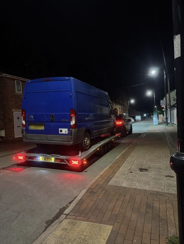 Blue Citroën Relay long-wheelbase van on the transporter on a street at night